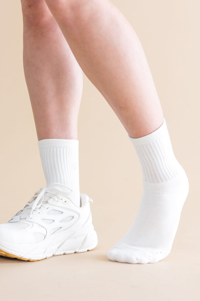 Adult Crew Socks in Cloud shown on models feet with a white sneaker on the right foot