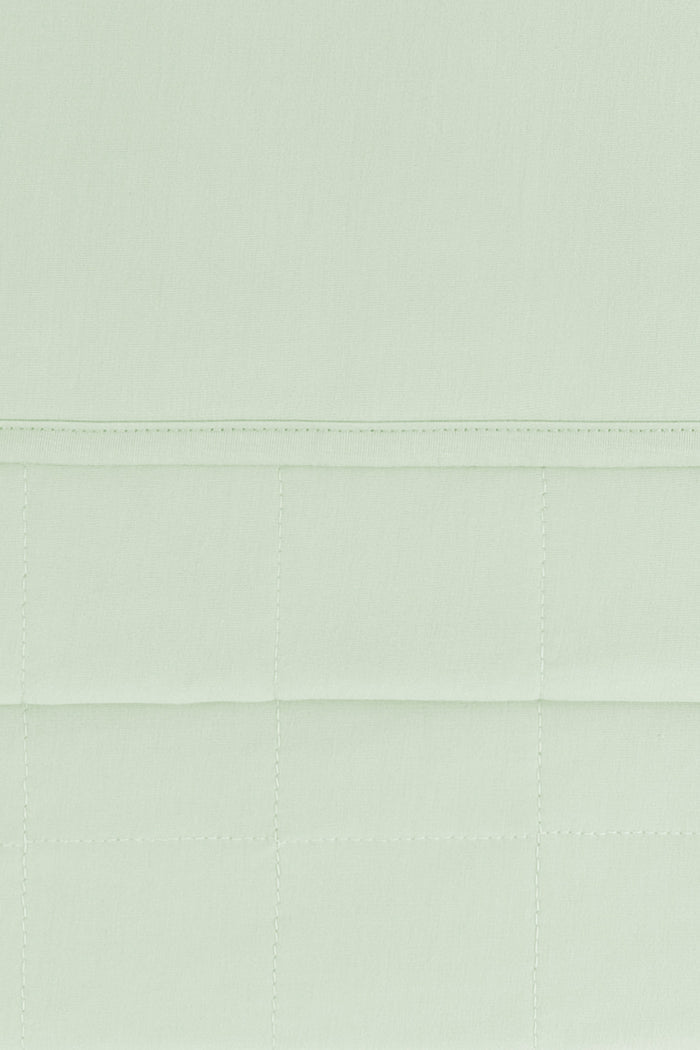 Close up of the quilted bottom and smooth top layer of the Adult Quilted Blanket in Basil 2.5