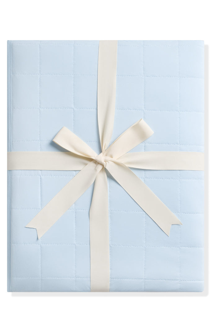 Product photo of the Adult Quilted Blanket in Breeze 1.0 shown tied in its linen ribbon
