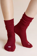 Model wearing Adult Scrunch Socks in Ruby shown on a beige background