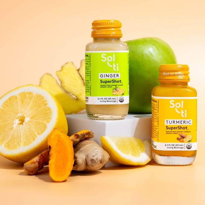 TURMERIC and GINGER SuperShot, next to ginger root, green apple, turmeric root  and, lemon slices