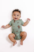 Baby wearing Green Bodysuit in Groot print lying on a white background