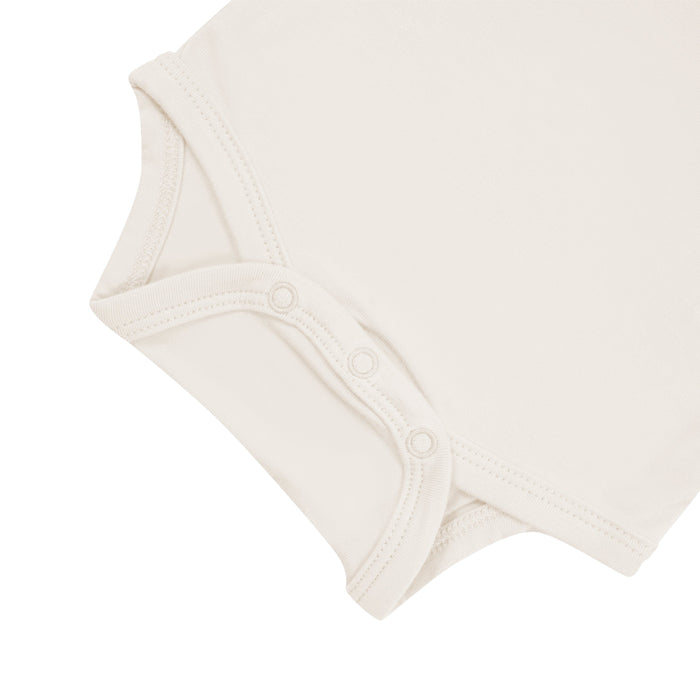 Close up of snap bottom of Kyte Baby  Bodysuit in Oat