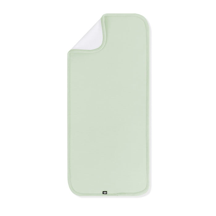 Soft and absorbent Burp Cloth in Basil laid flat with the corner folded down showing the bamboo terry backing