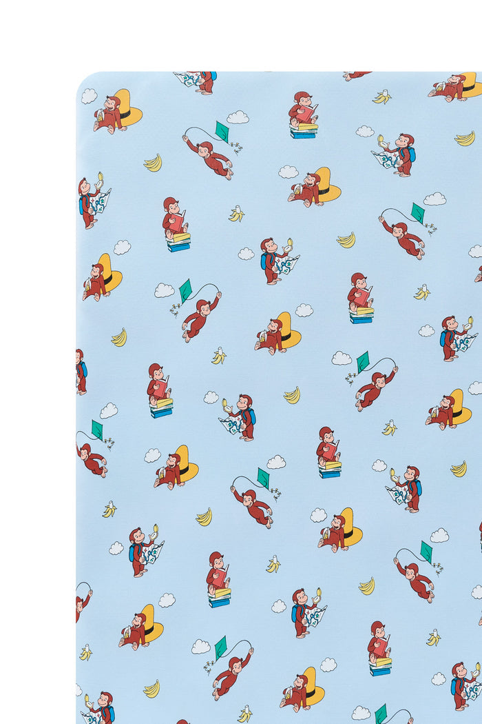 Close up of Blue Crib Sheet in Curious George print on a white background