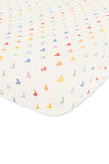 Crib sheet with pastel mickey mouse pattern on an oat background
