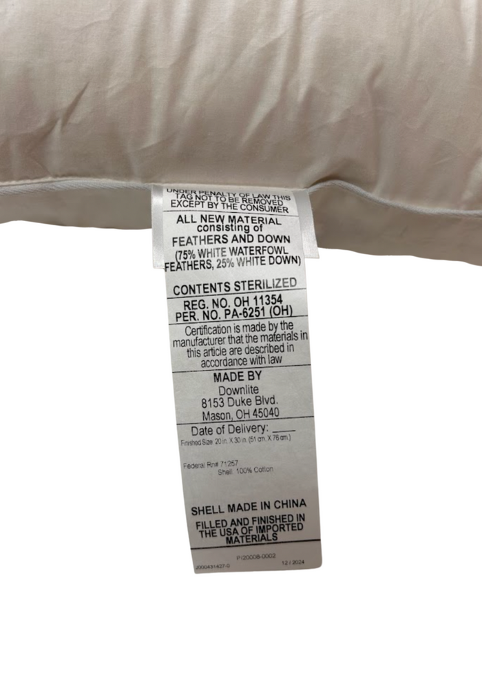 A close-up of the Pillow Factory Downlite 75/25 Waterfowl Feather/White Down Pillow tag shows contents as 75% white waterfowl feather, 25% white down; assembled in the USA from materials made in China.