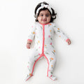Young infant laying on a white surface wearing the Footie in Tulip with matching knotted bow headband