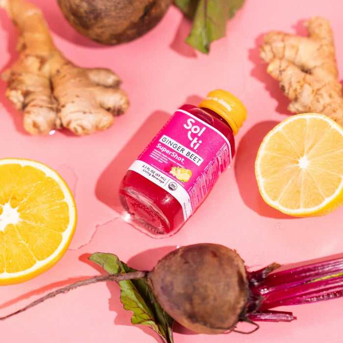 GINGER BEET SuperShot bottle with front label next to lemon slices, ginger root, and beet root