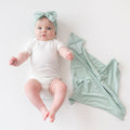 Baby wearing cloud bodysuit and Bow Headband in Sage next to Kite Lovey in Sage