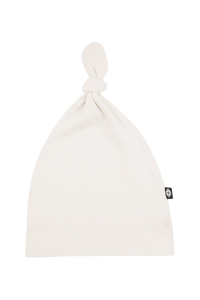 Flat lay of Kyte Baby Knotted Cap in Oat