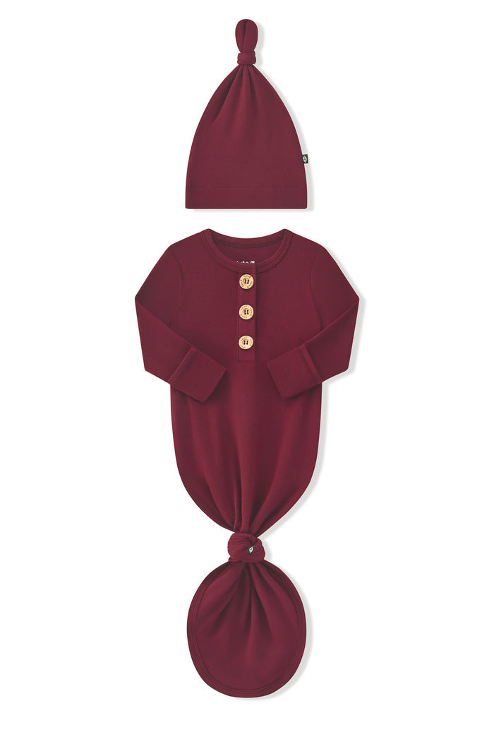 Arms of the Knotted Day Gown with Hat Set in Burgundy folded inward showing the fold over hand cuffs on a white background