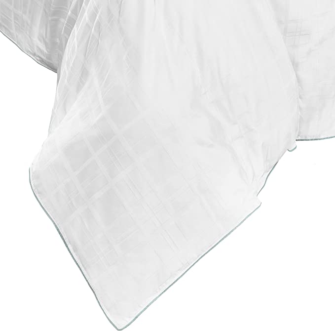 A Live Comfortably Cooling Cameron Tartan Comforter from Hollander, with a checkered pattern design, showcasing a fluffy texture and neatly stitched edges, draping softly over the corner of a bed.