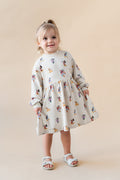 Toddler girl smiling wearing a long sleeve skater dress in mickey mouse & friends.