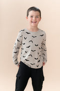 Boy wearing Long Sleeve Toddler Crew Neck Tee in Bats print over black pants on a beige background