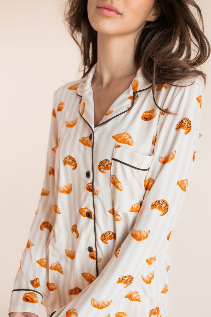 Close up of model wearing Long-Sleeved Women's Pajama Set with Croissant print on a beige background