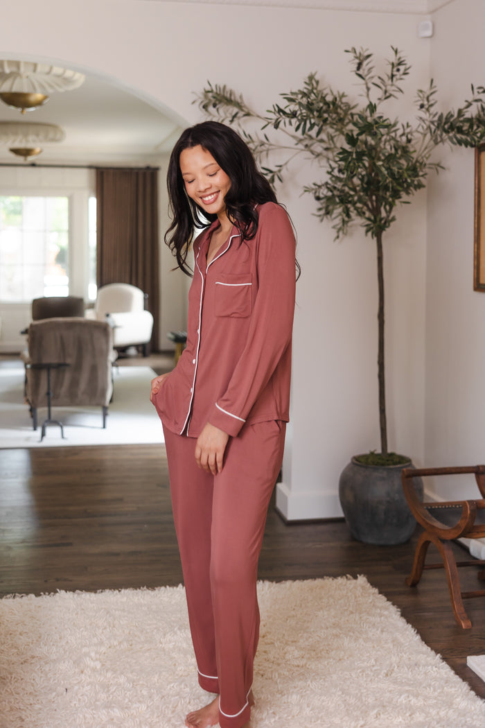 Modal smiling in Long-Sleeved Women's Pajama Set in Ember standing in a living room