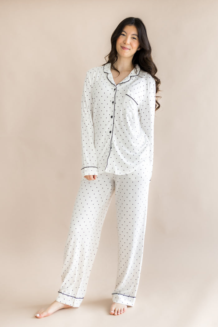 Model wearing Midnight Polka Dot print Women's long sleeve pajama set on a beige background