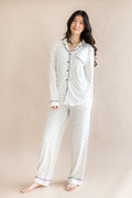 Model wearing Midnight Polka Dot print Women's long sleeve pajama set on a beige background