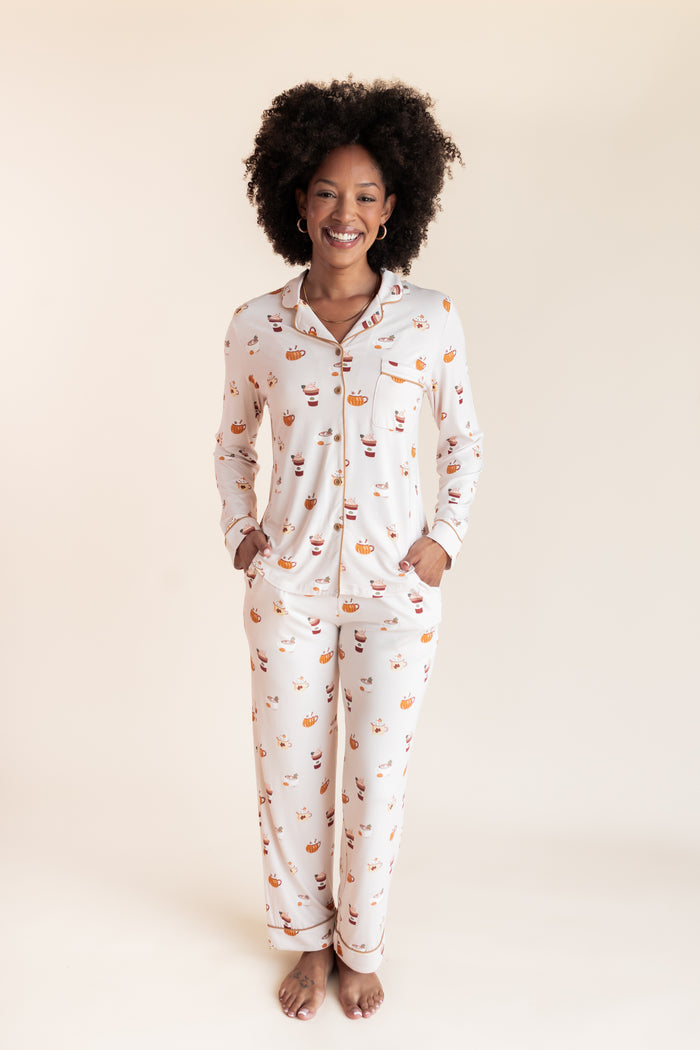 Model smiling in Long-Sleeved Women's Pajama Set with Pumpkin Spice Latte print on a beige background