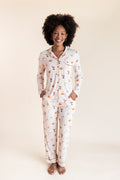 Model smiling in Long-Sleeved Women's Pajama Set with Pumpkin Spice Latte print on a beige background