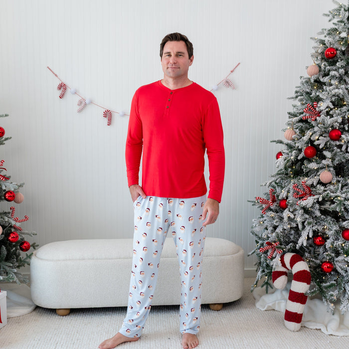Male model standing wearing the Men's Long Sleeve Henley Top in Cardinal with his one hand in the pocket of the Men's Vintage Santa Lounge pant