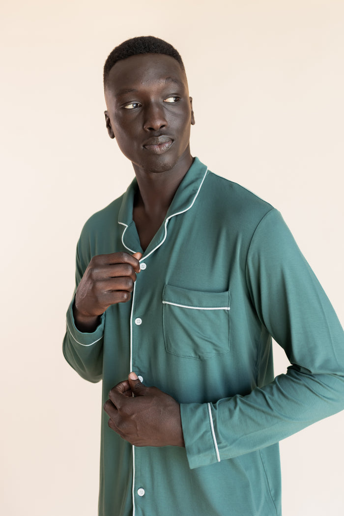 Close up of Model wearing Men's Long Sleeve Pajama Set in Pine on a beige background