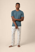 Man wearing a blue t-shirt and baseball patterned pants on a beige background