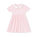 Pink dress with a white collar on a white background