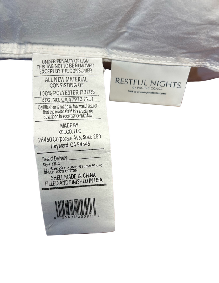 A close-up view of a Restful Nights Trillium Pillow label revealing care instructions, material composition (gel polyester fiber), brand "restful nights," and 230 thread count information. The tag also includes