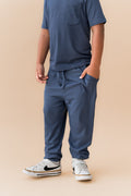 Child wearing Ribbed Jogger Pant in Oxford under Toddler Crew neck tee on a beige background