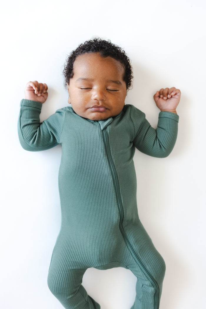 Close up of Baby sleeping in Ribbed Zipper Footie in Pine on a white background