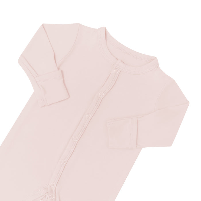Close up of top portion of Kyte Baby  Romper in Blush with arms folded in
