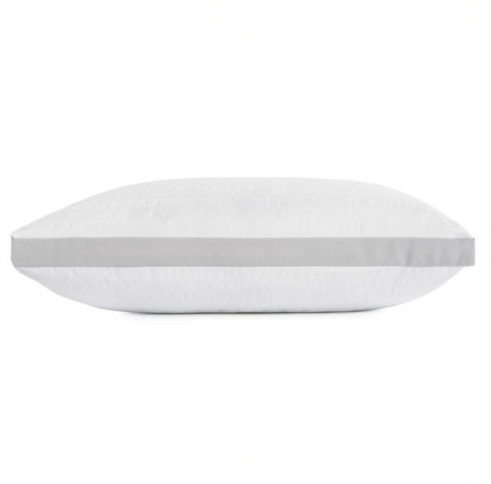 The Keeco Serta Dream Loft Pillow, showcased in a side view, is white and rectangular with a subtly quilted, textured surface. It features a horizontal grey stripe running across the center. Crafted from hypoallergenic SupraLoft premium fiber, the super soft seersucker fabric guarantees ultimate comfort. The background is plain white.