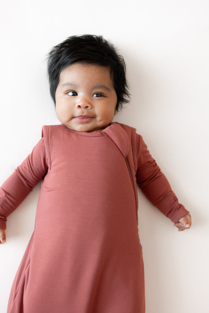 Close up of Baby smiling in Sleep Bag in Ember 1.0 on a white background