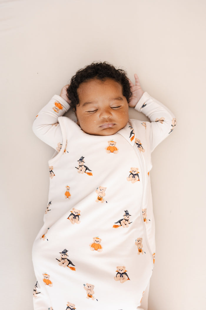 Close up of Baby sleeping in Sleep Bag in Halloween Teddy 1.0 print on a beige background