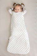 Baby wearing Sleep bag in Midnight Polka Dot print on a beige background