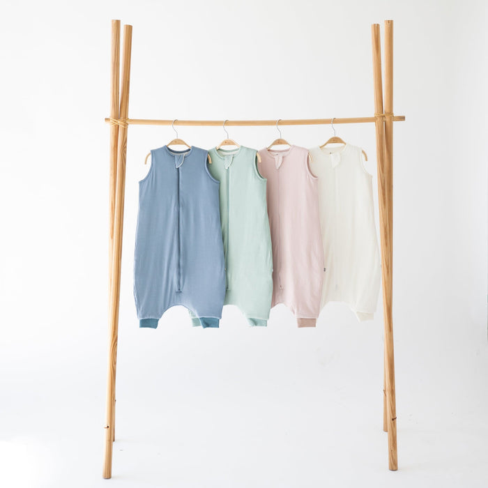 Kyte Baby sleep bag walkers 1.0 in Slate, Sage, Blush and Cloud hanging on wooden racks