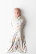 Baby asleep in kyte baby swaddle bag with pastel mickey head pattern