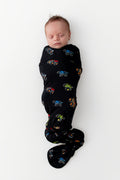 Baby sleeping in Black Swaddle Blanket in Monster Truck print on white background