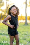 Young girl posing in front of trees wearing the Tank Jogger Set in Midnight