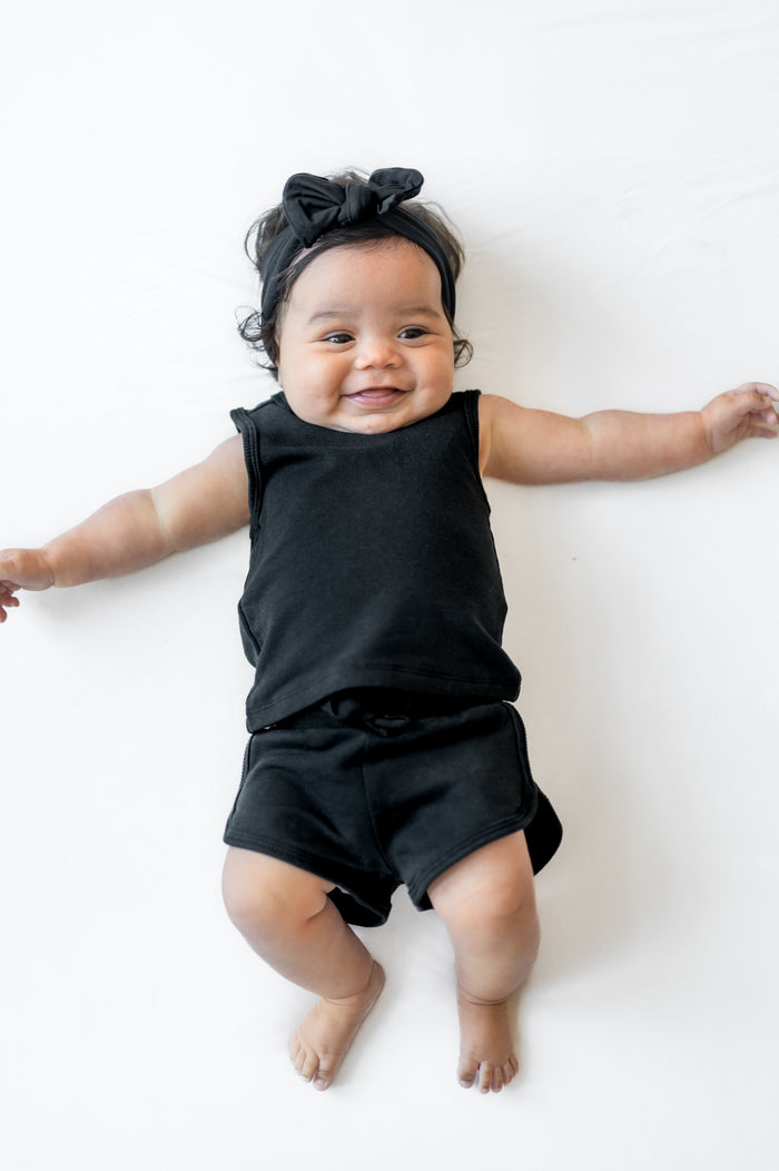 Infant laying on a white surface wearing the Tank Jogger Set in Midnight