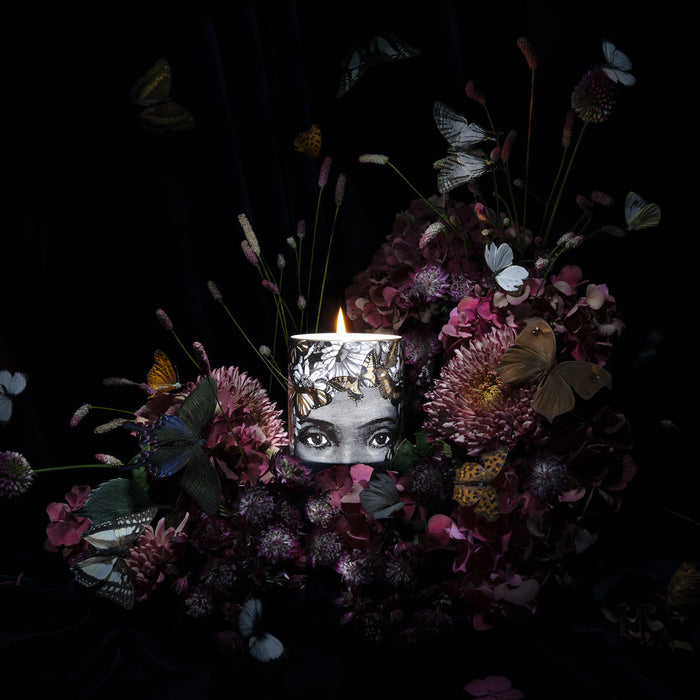 The Butterfly Lady ceramic candle lit, showing the warm glow of the flame in the fine china vessel