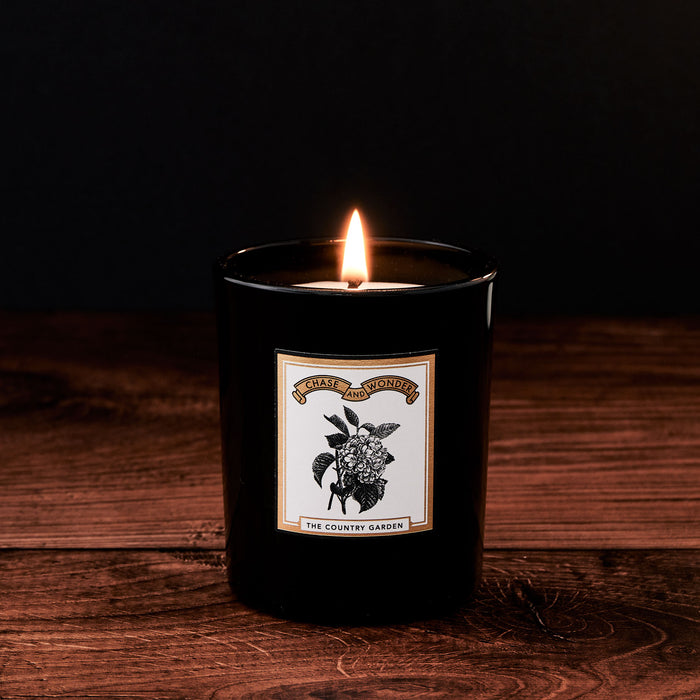 The Country Garden Luxury Scented Glass Candle by Chase and Wonder, elegant black glass vessel with gold lid
