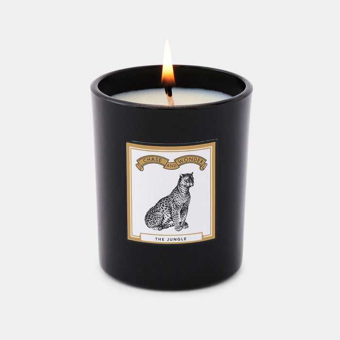 The Jungle scented glass candle lit, warm glow through black glass