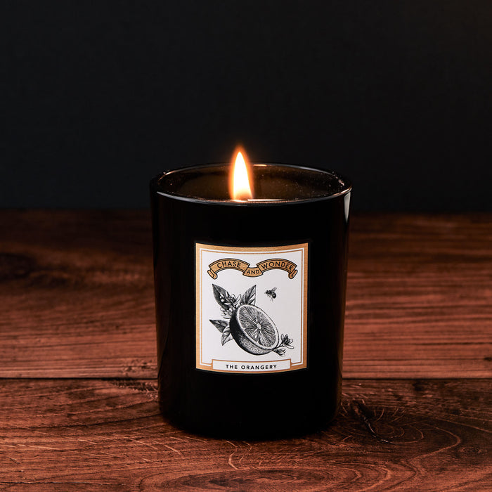 The Orangery Glass Candle by Chase and Wonder, elegant black glass vessel with gold lid