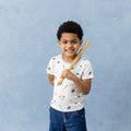 Young boy wearing the Toddler Basic Tee in Home Run holding a miniature wooden baseball bat