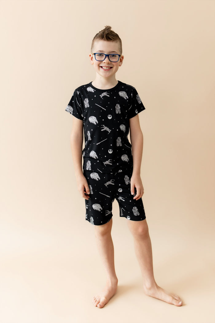 Young boy standing wearing the Toddler Basic Tee in STAR WARS™ paired with matching drawstring shorts