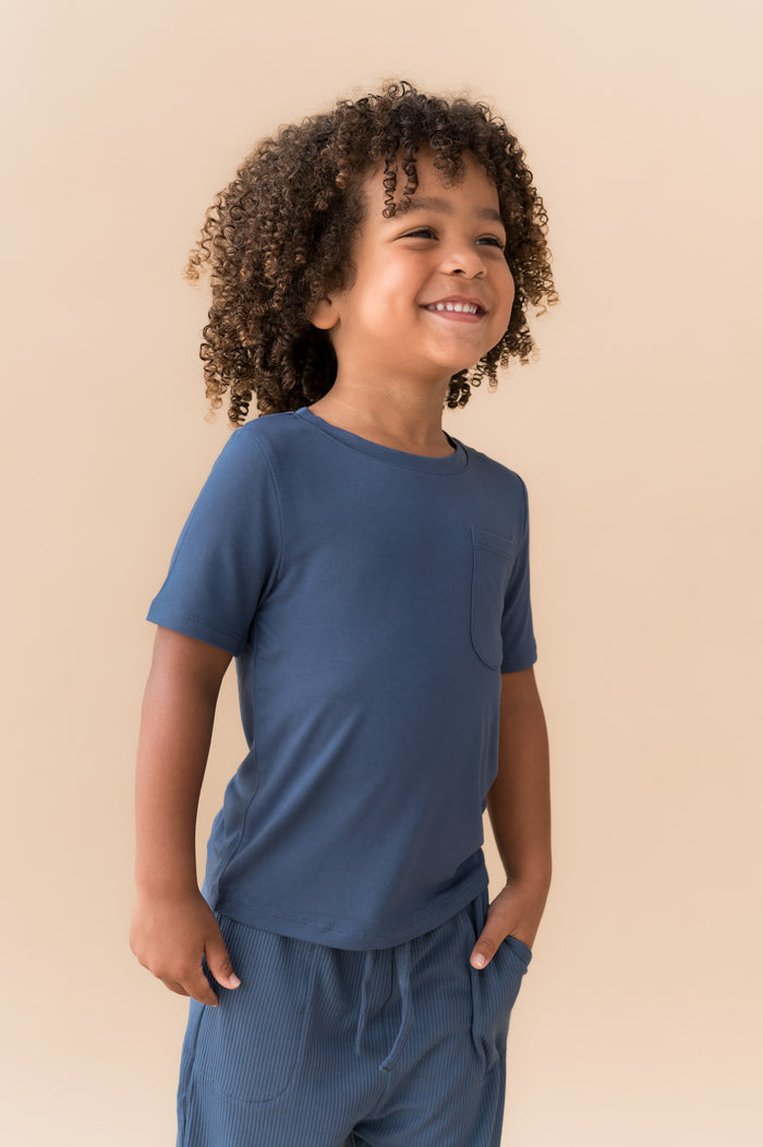Child smiling in Toddler Crew Neck Tee in Oxford on a beige background
