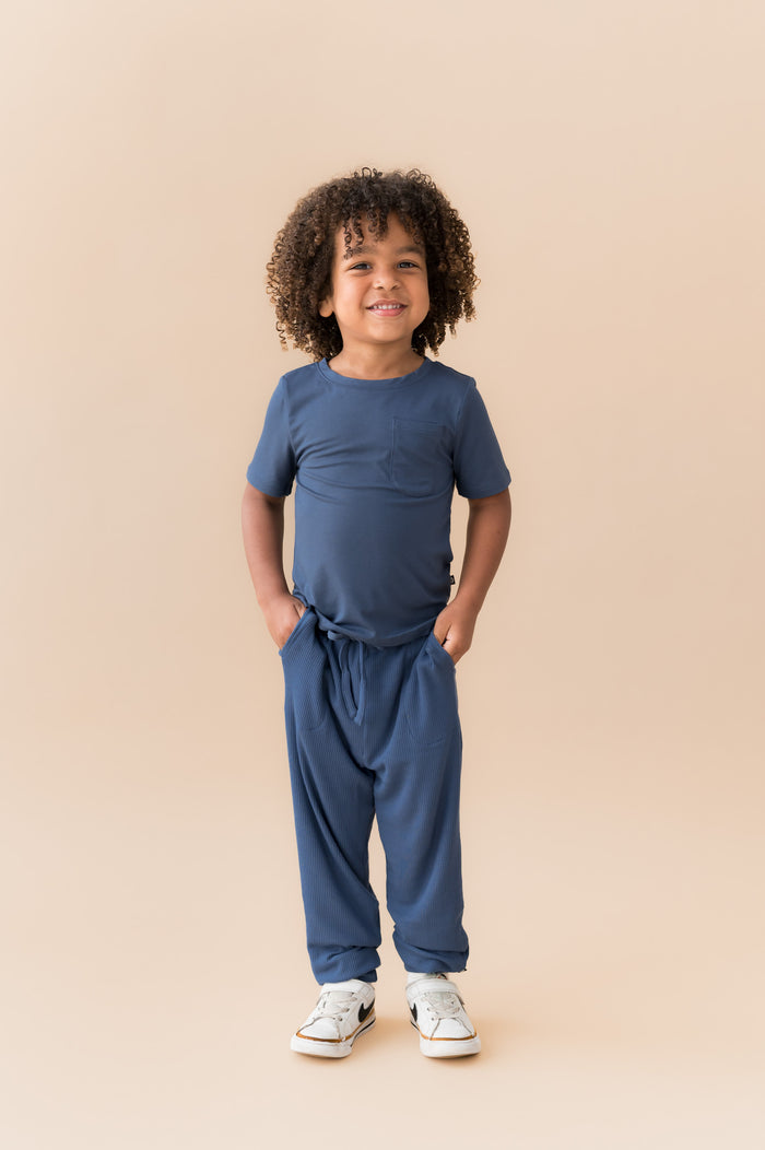Child wearing Ribbed Jogger Pant in Oxford under Toddler Crew neck tee on a beige background
